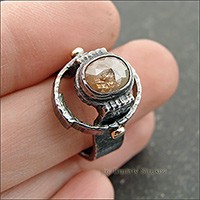 Перстень с алмазом бежевого цвета.